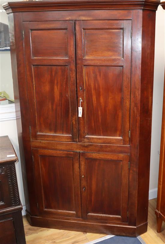 An early 19th century mahogany panelled standing corner cupboard H.180cm
